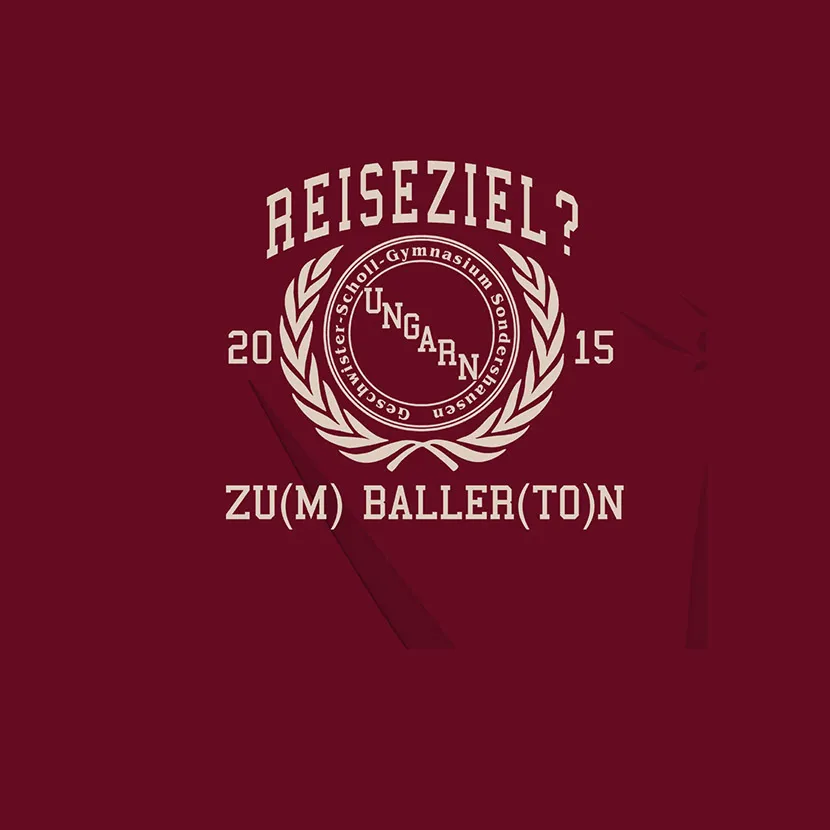 Weiße Grafik mit Text "Reiseziel?" und "Zu(m) Baller(Ton)" sowie einem Lorbeerkranz auf bordeauxrotem Hintergrund.