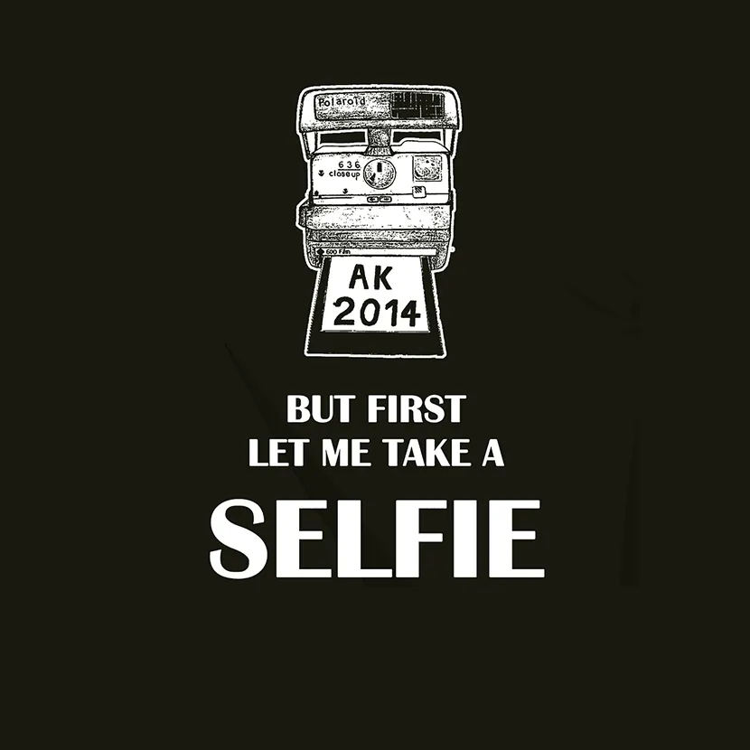 Eine Vintage-Polaroidkamera mit Text "BUT FIRST LET ME TAKE A SELFIE" und Jahreszahl 2014.